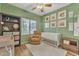 Cozy green Bedroom with a white crib, plush rug, a comfortable chair, and natural light from a large window at 5206 W Desert Hills Dr, Glendale, AZ 85304