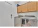 Functional laundry room with modern washer and dryer units and cabinet storage at 5206 W Desert Hills Dr, Glendale, AZ 85304