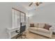 Bright home office with a white desk, comfortable chair, neutral sofa, and natural light from a window at 5206 W Desert Hills Dr, Glendale, AZ 85304