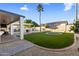 Expansive backyard featuring a pristine lawn, a refreshing pool, and a covered outdoor space for leisure at 5210 E Danbury Rd, Scottsdale, AZ 85254