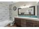 Bathroom with double sink vanity, large mirror, shower-tub combination, and stylish wood-look floor at 5210 E Danbury Rd, Scottsdale, AZ 85254