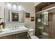 Cozy bathroom features a sink vanity, large mirror, and glass shower with neutral colored tile at 5210 E Danbury Rd, Scottsdale, AZ 85254