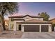 Beautiful two-story home with a three-car garage and a well-manicured front yard at dusk at 5210 E Danbury Rd, Scottsdale, AZ 85254