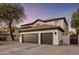 Exterior showcasing a spacious three-car garage and desert landscaping for curb appeal at 5210 E Danbury Rd, Scottsdale, AZ 85254