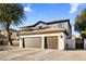 Exterior showcasing a spacious three-car garage, well-manicured lawn and desert landscaping at 5210 E Danbury Rd, Scottsdale, AZ 85254