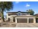 Elegant home with three-car garage, desert landscaping, and a welcoming front entrance at 5210 E Danbury Rd, Scottsdale, AZ 85254