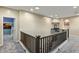 Second story landing with carpeted floor and wood railing, providing a safe and stylish transition between floors at 5210 E Danbury Rd, Scottsdale, AZ 85254