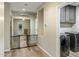 Hallway leads to laundry room showcasing gray cabinets and a modern washer and dryer set at 5210 E Danbury Rd, Scottsdale, AZ 85254