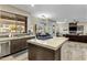 Kitchen with a large island and stainless steel dishwasher, open to the living room with fireplace at 5210 E Danbury Rd, Scottsdale, AZ 85254