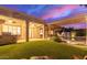 Backyard with covered patio, pool, putting green and artificial turf at twilight at 6159 W Sequoia Dr, Glendale, AZ 85308