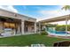 Expansive backyard featuring a manicured lawn, covered patio, and pool at 6159 W Sequoia Dr, Glendale, AZ 85308