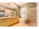 Bathroom featuring a double sink vanity, soaking tub, and a walk-in shower at 6159 W Sequoia Dr, Glendale, AZ 85308