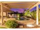 Picturesque pool area with lush landscaping, covered patio, and evening sky at 6159 W Sequoia Dr, Glendale, AZ 85308