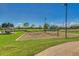 Community volleyball court with well-maintained sand and surrounding green space under a clear sky at 6159 W Sequoia Dr, Glendale, AZ 85308