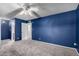 This bedroom features a ceiling fan, plush carpeting, and a calming blue accent wall at 6507 N 44Th Ave, Glendale, AZ 85301