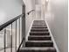 Carpeted staircase with black railing leading upstairs, providing a transition between floors at 6507 N 44Th Ave, Glendale, AZ 85301