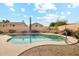 A serene backyard features a sparkling pool and desert landscaping for easy maintenance at 6717 E Saddleback Cir, Mesa, AZ 85215