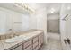 A well-lit bathroom has double sinks and a shower-tub combo with tiled walls at 6717 E Saddleback Cir, Mesa, AZ 85215