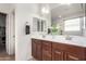 Bathroom featuring double sinks with white countertops, dark wood cabinets, and a large mirror at 7221 W Wood St, Phoenix, AZ 85043