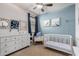 Charming Bedroom with blue accent wall, crib, dresser, and ceiling fan at 7221 W Wood St, Phoenix, AZ 85043