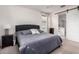 Relaxing bedroom featuring carpet floors, ceiling fan, and a large bed with a tufted headboard at 7221 W Wood St, Phoenix, AZ 85043