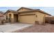 Inviting home featuring a two-car garage, desert landscaping, and a charming covered entryway at 7221 W Wood St, Phoenix, AZ 85043