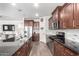 Modern kitchen featuring dark wood cabinets, granite countertops, stainless steel appliances, and hardwood floors at 7221 W Wood St, Phoenix, AZ 85043