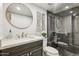 Modern bathroom featuring stylish vanity, round mirror, and sleek glass-enclosed shower at 7800 E Lincoln Dr # 1007, Scottsdale, AZ 85250