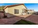 View of the home's backyard with a partially xeriscaped yard with a covered patio, and beige exterior at 815 E Centre Ave, Buckeye, AZ 85326