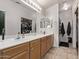 Bathroom featuring double sinks with wood cabinetry, a shower/tub combo, and a walk-in closet at 815 E Centre Ave, Buckeye, AZ 85326