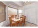 Sunlit dining room with a wooden table and chairs, and a large window with blinds at 815 E Centre Ave, Buckeye, AZ 85326