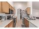 Efficient kitchen layout with stainless steel appliances, wood cabinets, and tiled flooring at 815 E Centre Ave, Buckeye, AZ 85326