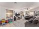 Open living room with tile flooring, neutral walls, ceiling fan, and a large comfortable sectional sofa at 815 E Centre Ave, Buckeye, AZ 85326