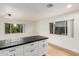 Kitchen island with black countertop, white cabinets, and natural wood flooring at 8252 E Heatherbrae Ave, Scottsdale, AZ 85251