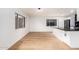 Open floorplan with hardwood floors connects the living room to the kitchen featuring modern black appliances at 8252 E Heatherbrae Ave, Scottsdale, AZ 85251