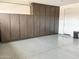 Garage with finished epoxy floors and brown cabinets running along the back wall at 8907 W Bethany Heights Dr, Glendale, AZ 85305