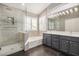 Modern bathroom with a large shower, soaking tub, double vanity, and black tile flooring at 901 N Woodburne Dr, Chandler, AZ 85224