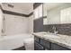 Stylish bathroom with marble tile in shower, gray vanity, and dark flooring at 901 N Woodburne Dr, Chandler, AZ 85224