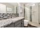 Elegant bathroom with tiled shower, granite vanity top, and dark wood floors at 901 N Woodburne Dr, Chandler, AZ 85224