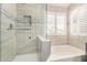 Bright bathroom featuring a tiled shower, soaking tub, and large window at 901 N Woodburne Dr, Chandler, AZ 85224