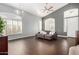 Spacious living room features wood-look tile flooring, plantation shutters, and a modern ceiling fan at 901 N Woodburne Dr, Chandler, AZ 85224