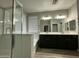 Modern bathroom featuring a glass-enclosed shower, a soaking tub, and a dual sink vanity with good lighting at 9017 W Kirby Ave, Tolleson, AZ 85353