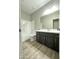 Clean bathroom featuring a shower-tub combo with a sleek dark vanity and light countertop and sink at 9017 W Kirby Ave, Tolleson, AZ 85353