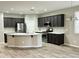 Modern kitchen with island, stainless appliances, quartz counters, dark cabinets and plank flooring at 9017 W Kirby Ave, Tolleson, AZ 85353