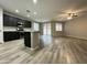 Bright, open kitchen featuring stainless steel appliances, dark cabinets, an island, and plank flooring at 9017 W Kirby Ave, Tolleson, AZ 85353