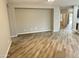 Spacious living room with plank flooring leading to arched doorway and kitchen area at 9017 W Kirby Ave, Tolleson, AZ 85353