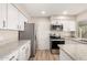 Bright kitchen featuring stainless steel appliances, granite countertops, and modern white cabinetry at 904 W Tulane Dr, Tempe, AZ 85283