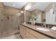 Elegant bathroom featuring double vanity, a large mirror, and a glass-enclosed shower at 908 E Cereus Pass, Queen Creek, AZ 85140