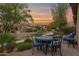 Outdoor patio featuring a round table with seating and lush landscaping at sunset at 908 E Cereus Pass, Queen Creek, AZ 85140