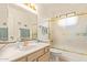 Bright bathroom features a tub/shower combination, single sink vanity, and a large mirror at 9329 W Topeka Dr, Peoria, AZ 85382